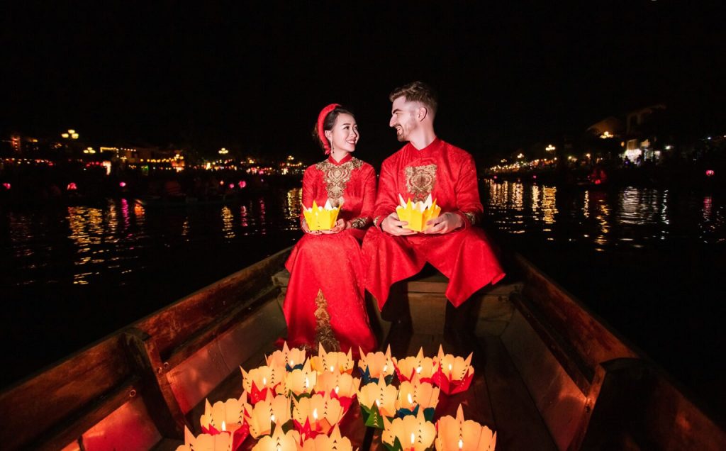 Couples releasing paper lanterns into the Hoai River.