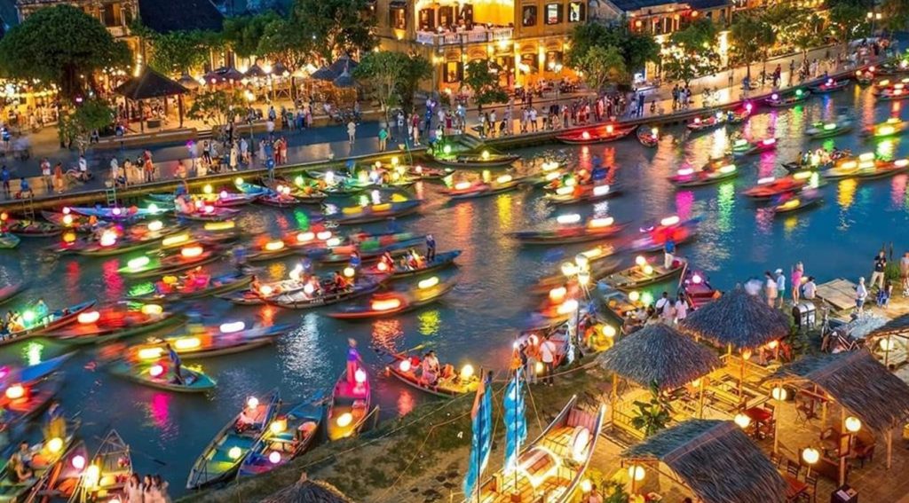 Hoi An Ancient Town at night with lanterns reflecting on the river.