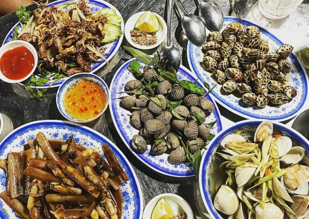 Tourists enjoying seafood by the beach.