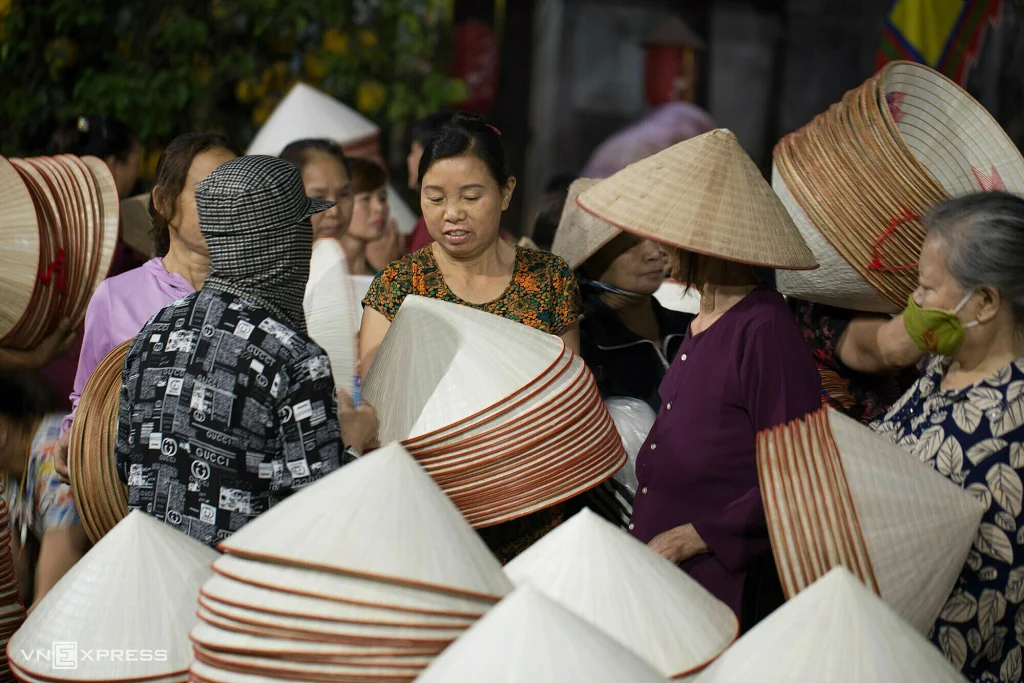 Local women selling conical hats and souvenirs.