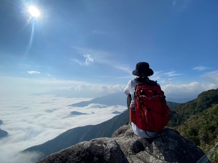 Travelers posing with the summit sign at Bach Ma peak