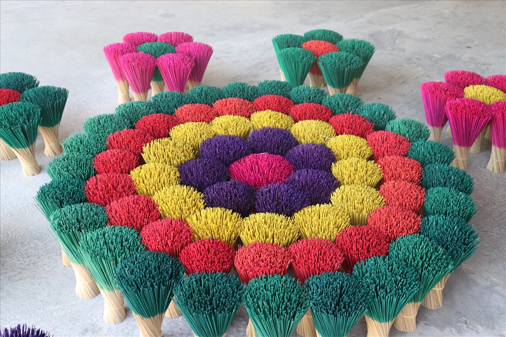 Aerial or wide shot of colorful incense bundles arranged like flowers.