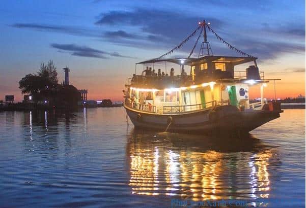Wide shot of fishing boats glowing under moonlight.