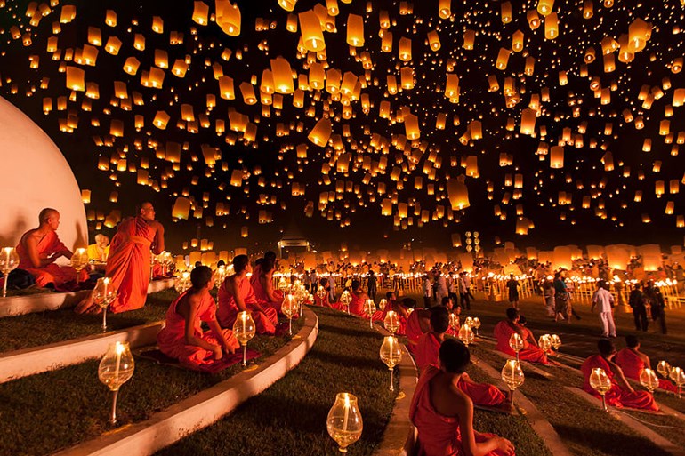 A sky full of glowing lanterns rising over Hoi An.