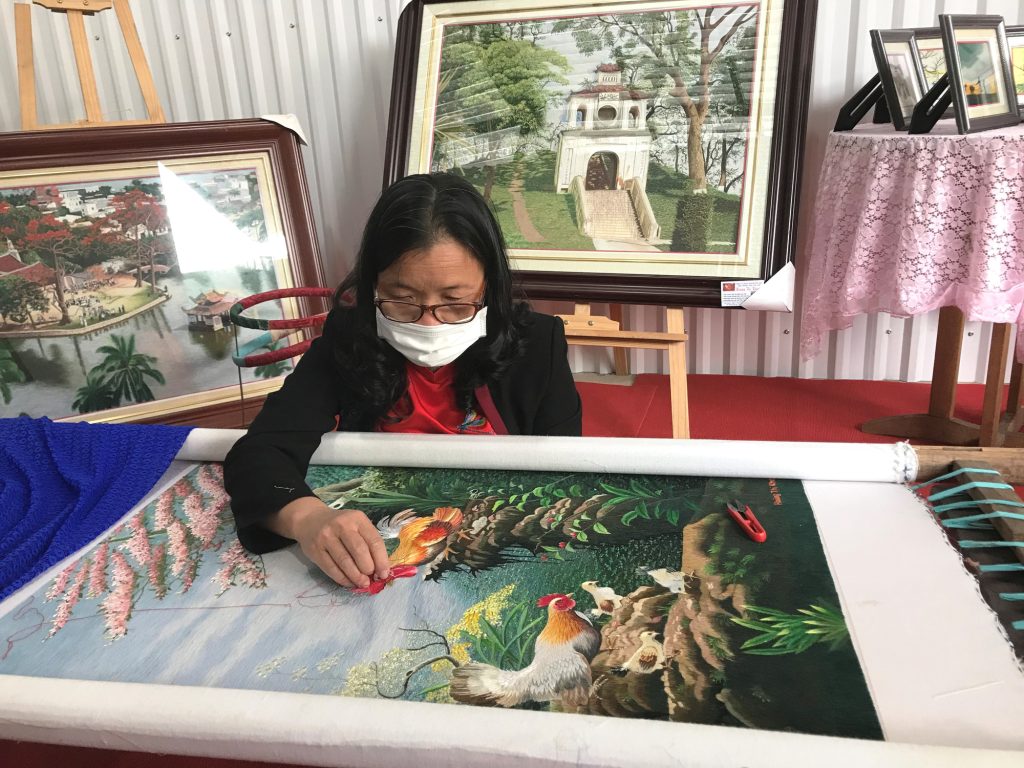 Close-up of artisans stitching.