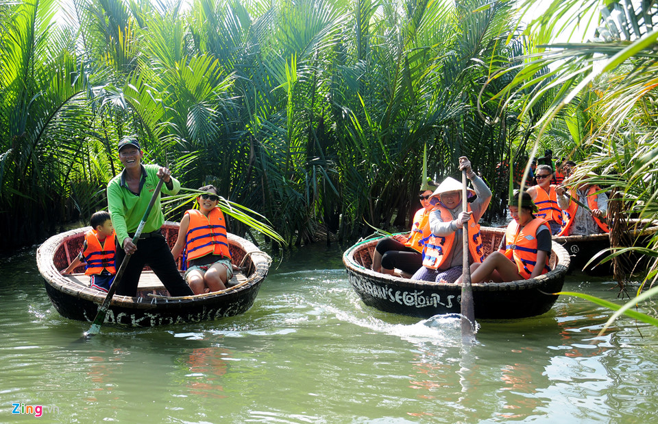 Tourists riding basket boats surrounded by green palms.