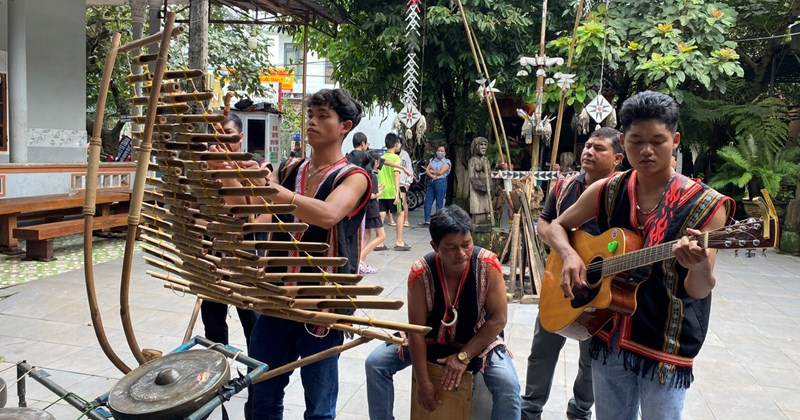 Visitor learning to play a drum with artisan guidance