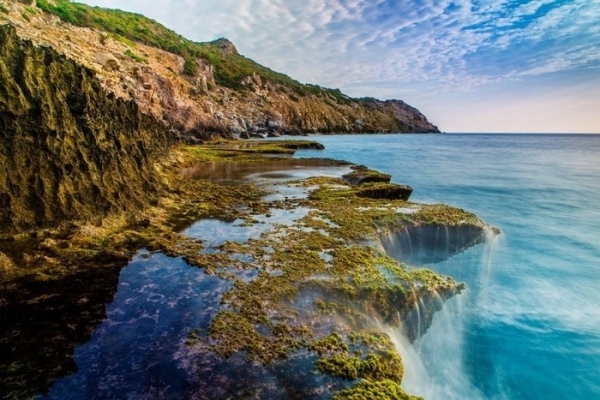 turquoise waves crashing onto the rocky shore